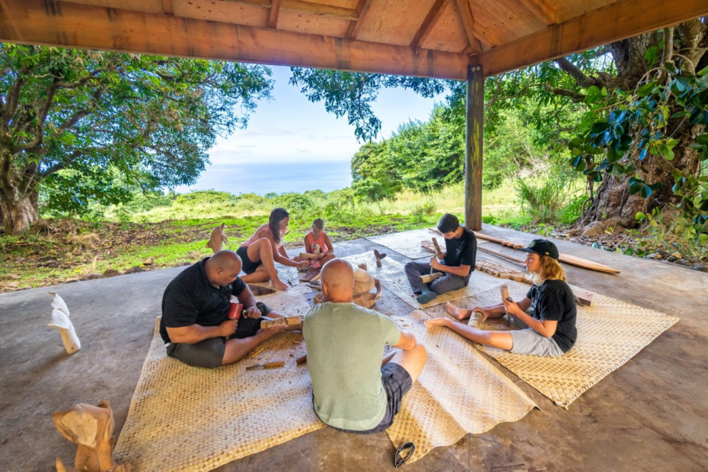 A tour group carving a tiki at Aloha Adventure Farms