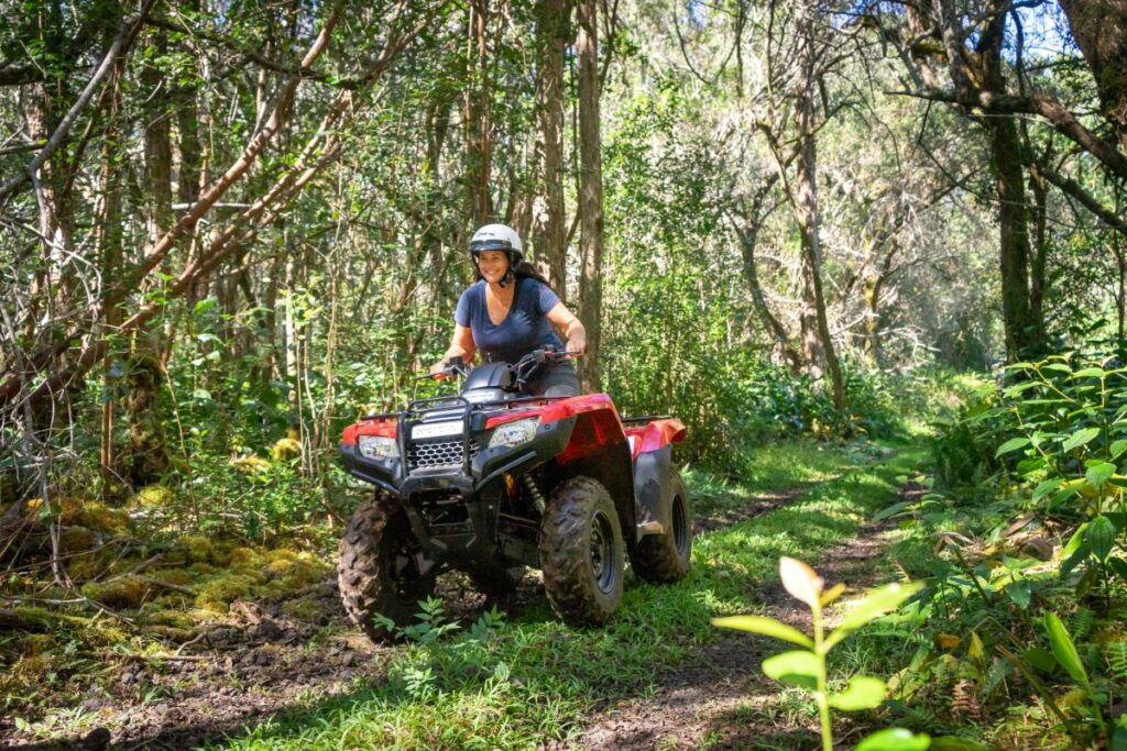 A woman riding a red ATV on the Big Island in Hawaii